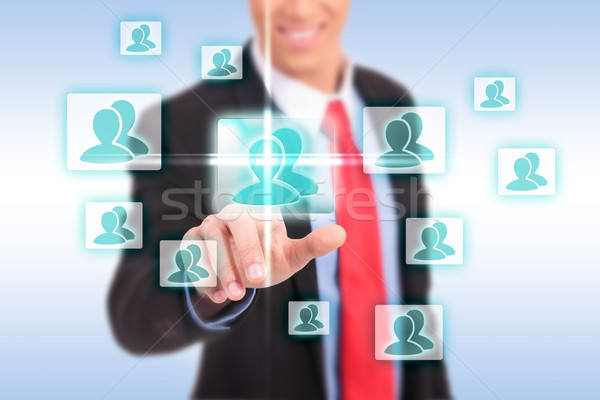 smiling business man pressing the add friend button Stock photo © feedough