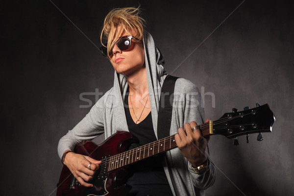 Blond jeune homme salissant cheveux jouer guitare Photo stock © feedough