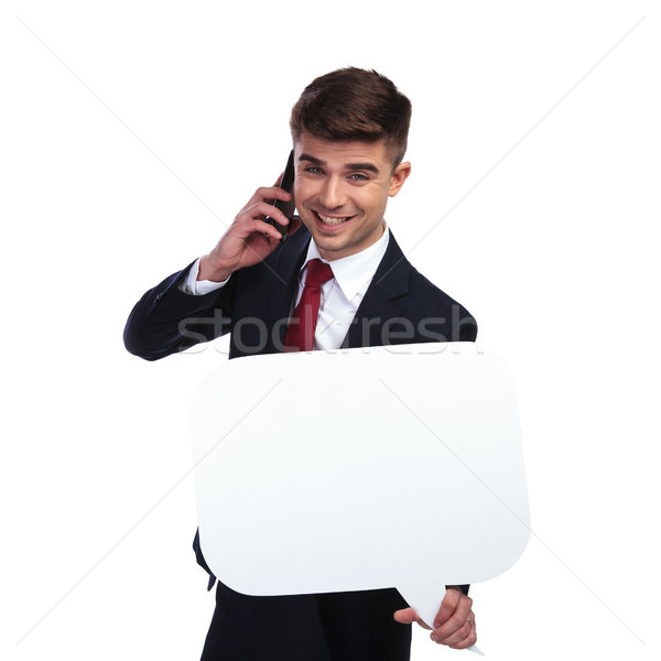 Stock photo: businessman on the phone laughs while holding white speech bubbl
