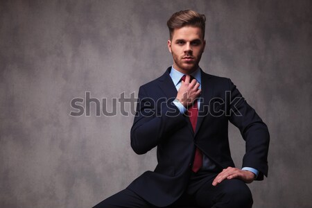 portrait of seated young businessman in tuxedo fixing his bowtie Stock photo © feedough