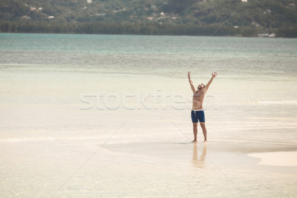 happy man on the beach holding both hands up Stock photo © feedough