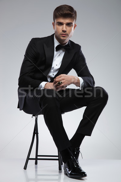 attractive seated stylish man in black tuxedo and black bowtie Stock photo © feedough