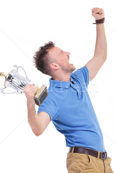 casual young man shouts with trophy in hand Stock photo © feedough