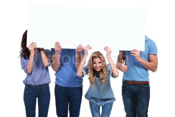 smiling woman holding banner with her friends hiding Stock photo © feedough