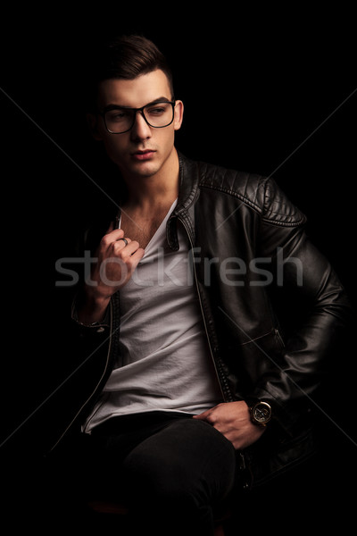 man in black leather jacket wearing glasses pulling his shirt  Stock photo © feedough
