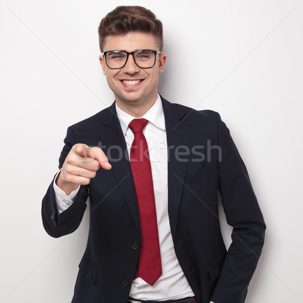 smiling businessman with glasses and navy suit points finger Stock photo © feedough