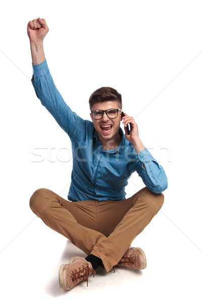seated casual man talking on the phone is celebrating success  Stock photo © feedough
