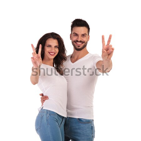 smiling young casual couple making victory or peace sign Stock photo © feedough