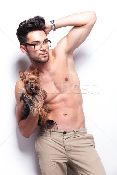 topless young man holds puppy and fixes hair Stock photo © feedough