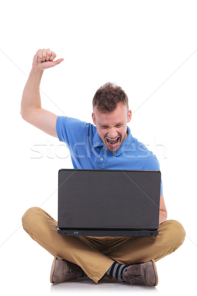 seated young casual man cheers with laptop Stock photo © feedough