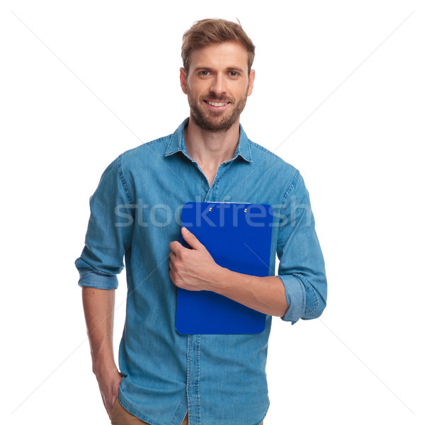 young casual man holding clipboard at his chest  Stock photo © feedough