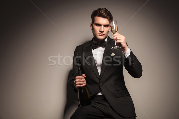 business man holding a bottle and a glass of champagne. Stock photo © feedough