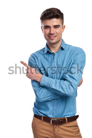 smiling casual man with hands crossed is pointing to side  Stock photo © feedough