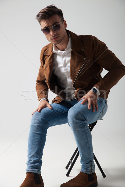 young man wearing sunglasses and leather jacket sitting  Stock photo © feedough
