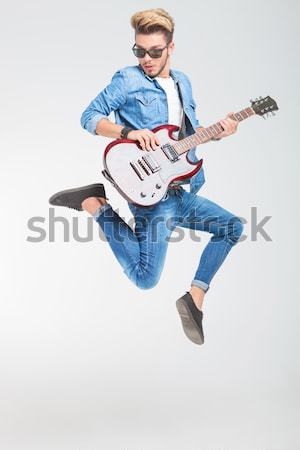 Stock photo: young man jumping with guitar