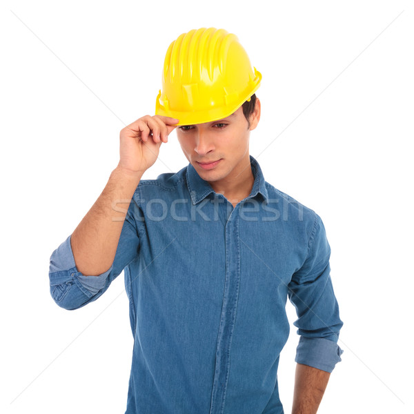 young construction engineer holding his safety helmet and looks  Stock photo © feedough