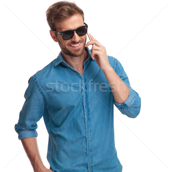 laughing young man wearing sunglasses talks on the phone  Stock photo © feedough
