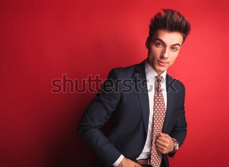 businessman in black with red tie fixing his jacket Stock photo © feedough