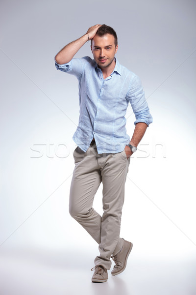 casual man fixing hair and with hand in pocket Stock photo © feedough