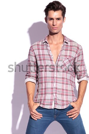 arrogant young casual man standing with hands in pockets Stock photo © feedough
