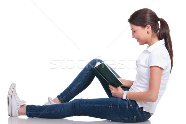 casual woman lays on floor & reads Stock photo © feedough