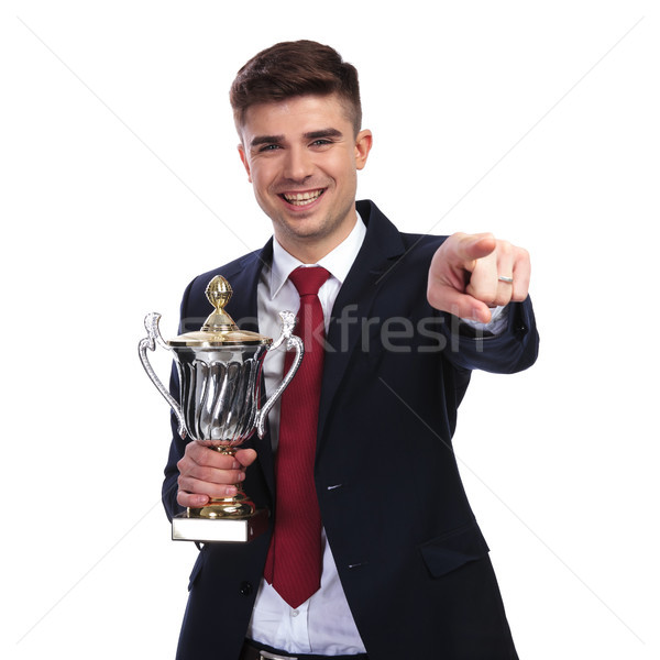 smiling businessman points finger while holding the awarded trop Stock photo © feedough