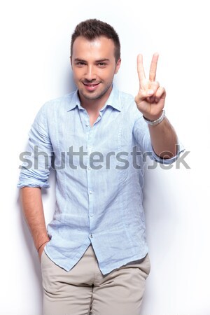 casual middle aged man sits and shows victory Stock photo © feedough
