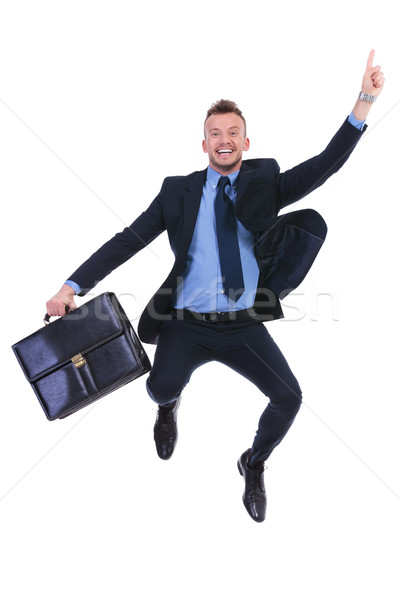 Stock photo: business man jumps and points with suitcase