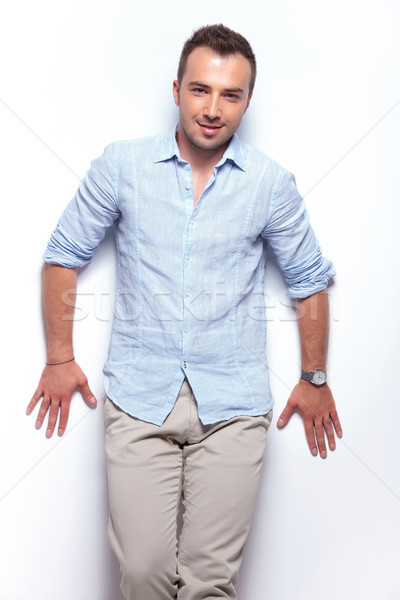 Foto stock: Casual · homem · inclinando-se · para · trás · estúdio · parede · jovem