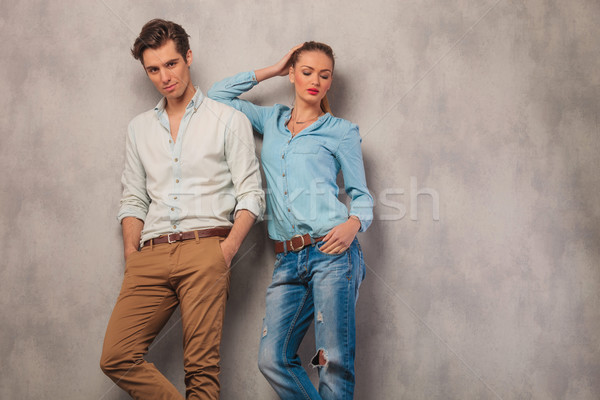 man pose in studio with hands in pockets while woman is resting  Stock photo © feedough