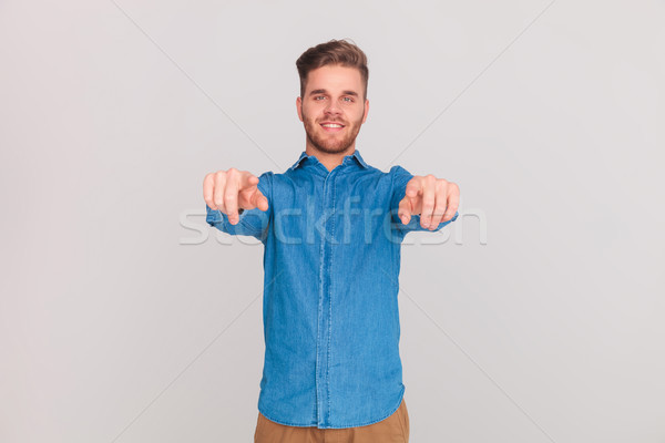 portrait of casual man in blue shirt pointing fingers Stock photo © feedough