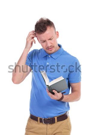 young casual man holds book and thinks Stock photo © feedough