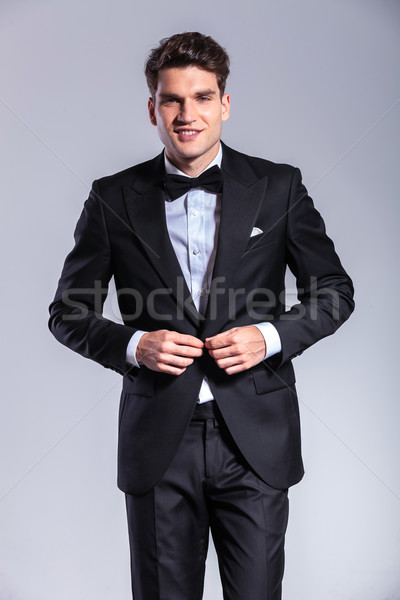 Happy young business man closing his jacket Stock photo © feedough