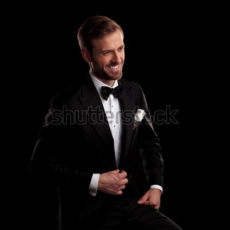 elegant young man wearing tuxedo and fixing his sleeve Stock photo © feedough