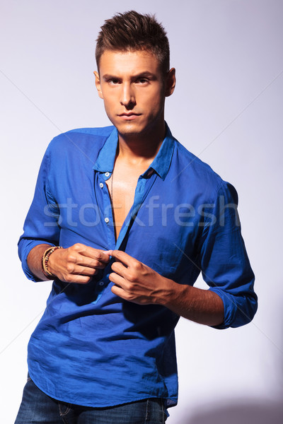 Stock photo: sexy man unbuttoning blue shirt