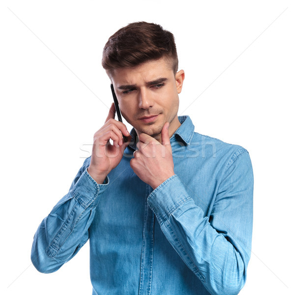 young casual man is pondering his decision on the phone  Stock photo © feedough