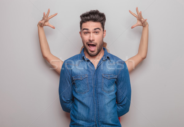 Casual young man making a funny face  Stock photo © feedough