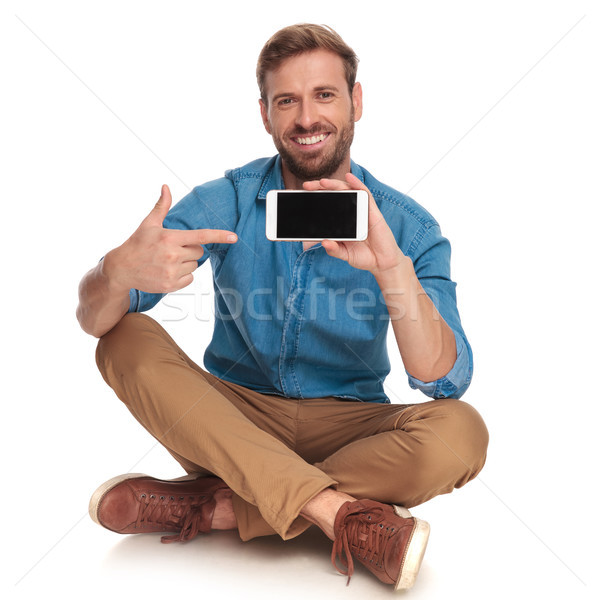 laughing seated casual man points finger to his phone Stock photo © feedough