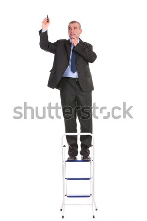 business man stands on ladder and draws Stock photo © feedough
