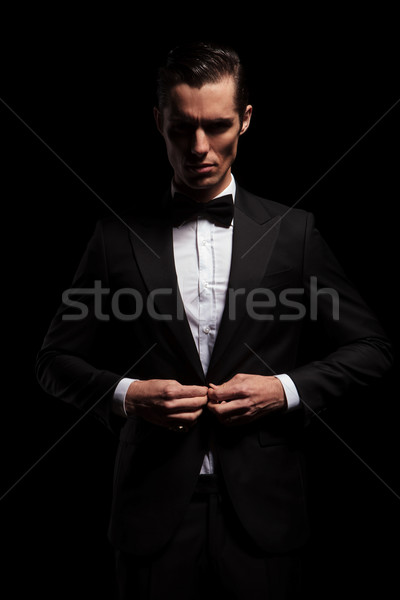 businessman in black toxedo with bowtie posing in dark studio Stock photo © feedough