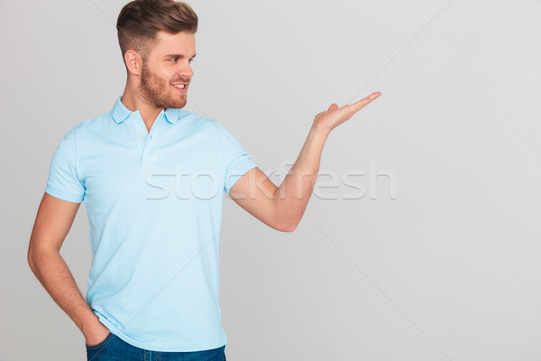relaxed casual man in light blue polo t-shirt presenting side Stock photo © feedough