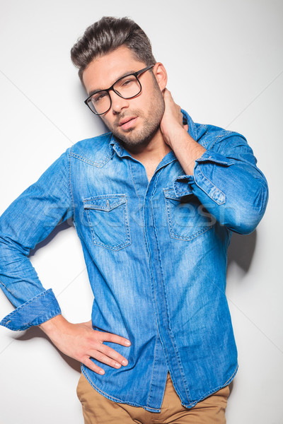 young beautiful man in denim touching his neck Stock photo © feedough