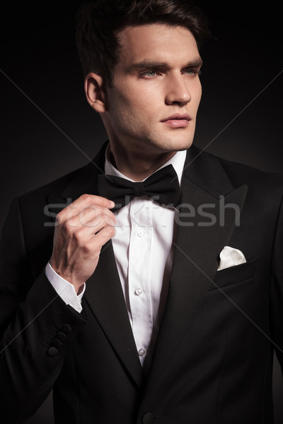 Handsome young elegant man fixing his bowtie. Stock photo © feedough