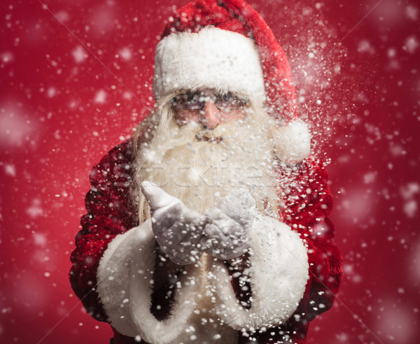 santa claus blowing snow flakes out of his hands Stock photo © feedough