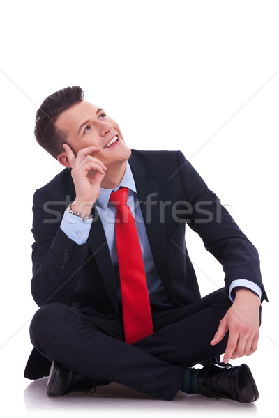 Stock photo: young seated business man looking up 