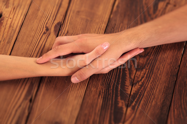 Hombre mujer tomados de las manos mesa de madera familia Foto stock © feedough