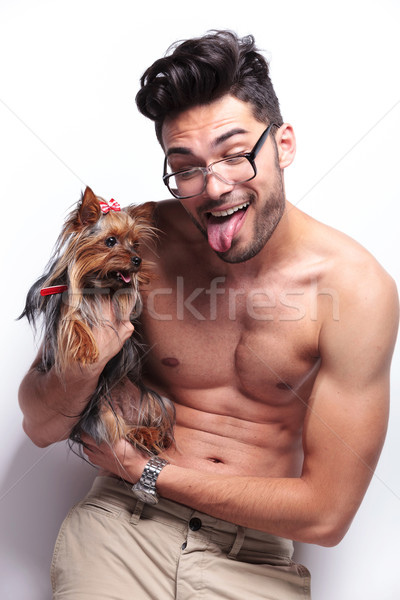 topless young man holds puppy with tongue out Stock photo © feedough