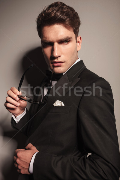 Stock photo: business man holding a pair of glasses in his hand