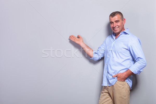 casual old man presents with hand in pocket Stock photo © feedough