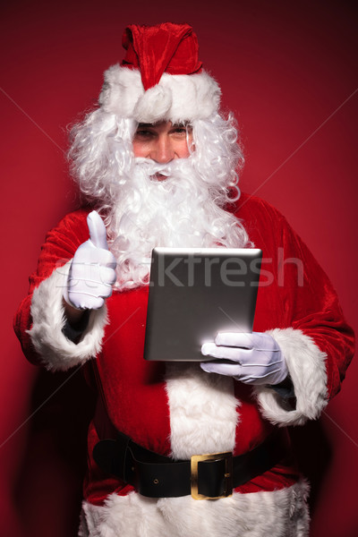 santa claus is reading about good news on his tablet pad Stock photo © feedough